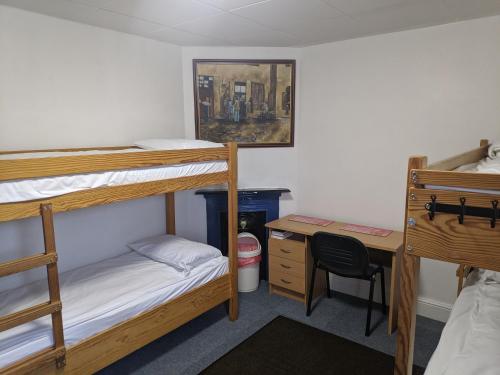 a dorm room with two bunk beds and a desk at HARLOW INTERNATIONAL HOSTEL in Harlow