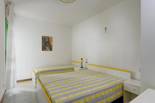 1 dormitorio con 2 camas y una cruz en la pared en Hibiscus, en Bibione