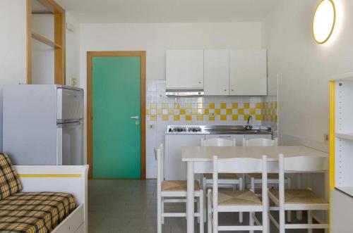 cocina con mesa y puerta verde en Hibiscus, en Bibione