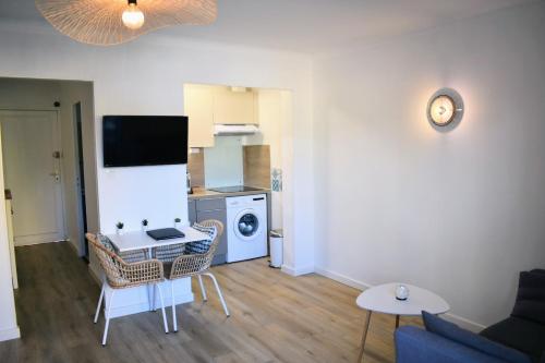 un salon avec un canapé et une table et une cuisine dans l'établissement Sanary Côté Mer, à Sanary-sur-Mer