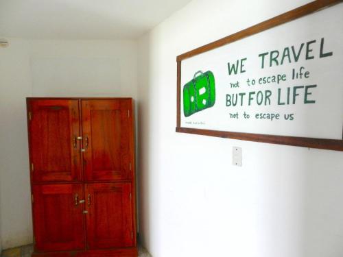 a room with a red cabinet and a sign on the wall at The Wave Hostel Corn Island in Corn Island