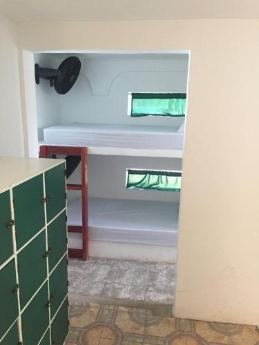 a room with a bed and a desk in a room at The Wave Hostel Corn Island in Corn Island