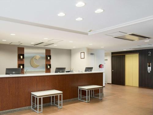 成田的住宿－成田機場康福特茵酒店，大堂设有2张凳子的柜台