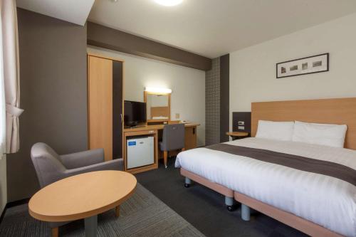 成田市にあるコンフォートホテル成田のベッドとデスクが備わるホテルルームです。