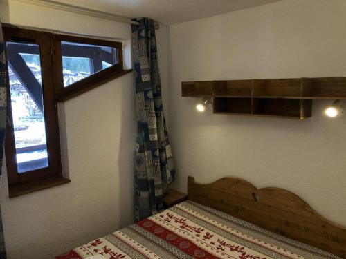 Appartement La Tania, 3 pièces, 6 personnes - FR-1-513-18 في لا تانيا: غرفة نوم صغيرة بها سرير ونافذة