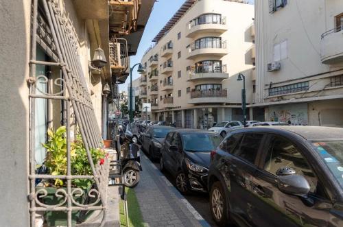 a street with cars parked on the side of the road at Ofek's place - NOGA in Tel Aviv