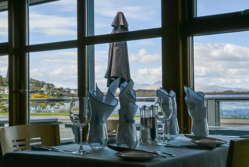 una mesa con copas de vino y una sombrilla. en Oyster Inn Connel en Oban