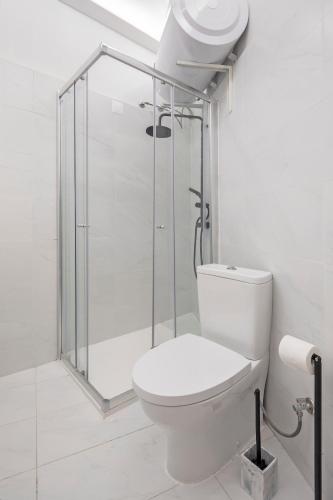 a bathroom with a toilet and a glass shower at Petit studio Rosa - Bairro Alto in Lisbon