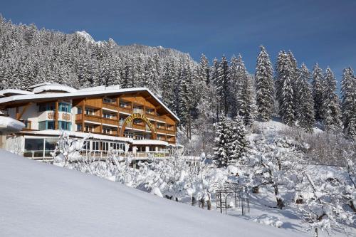 a lodge in the snow with snow covered trees at Hotel Talhof Garni&more in Wängle bei Reutte in Reutte