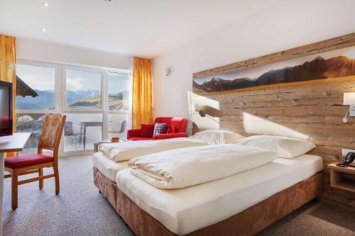 una camera con un grande letto e una parete in legno di Hotel Talhof Garni&more in Wängle bei Reutte a Reutte