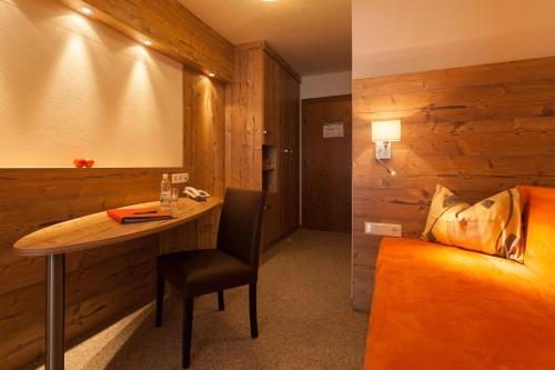 a room with a table and a bed and a desk at Hotel Talhof Garni&more in Wängle bei Reutte in Reutte
