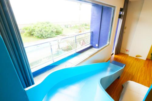 a room with a large window with a blue couch at Two Home Inn in Hualien City