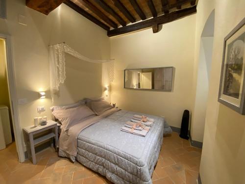 a bedroom with a bed and a mirror on the wall at Casina Bella in Cortona