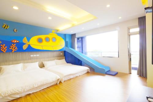 a bedroom with a bed with a fish painting on the wall at Two Home Inn in Hualien City
