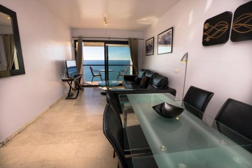een woonkamer met een glazen tafel en stoelen bij LAS VISTAS 2C MENYBER in Nerja