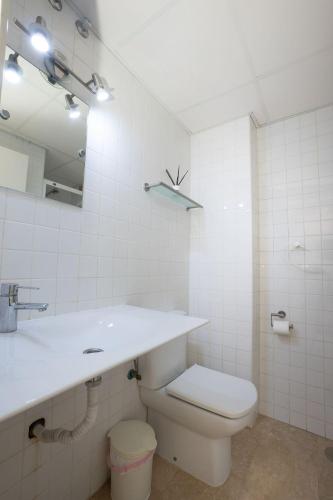 a white bathroom with a toilet and a sink at PLAYA DEL SALON 2c MENYBER in Nerja