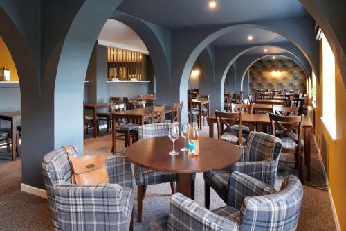 a dining room with tables and chairs in a restaurant at The Bridge House; BW Signature Collection in Ferndown