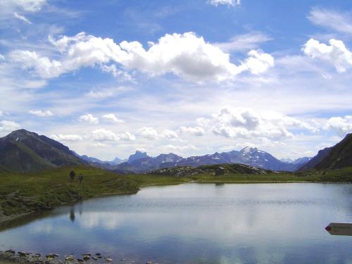 a lake in the middle of a valley with mountains at Pension Waldhof in Lech am Arlberg