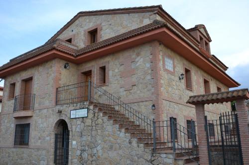 a building with stairs on the side of it at Apartamentos Rurales Natura in Torrejón el Rubio