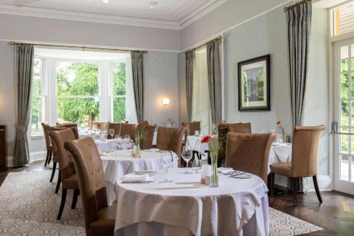 a restaurant with white tables and chairs and windows at Ness Walk in Inverness