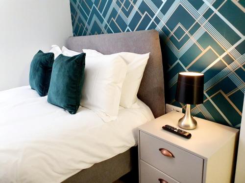 um quarto com uma cama com almofadas e uma mesa de cabeceira em Modern Town Centre Studio Close to Beach em Bournemouth