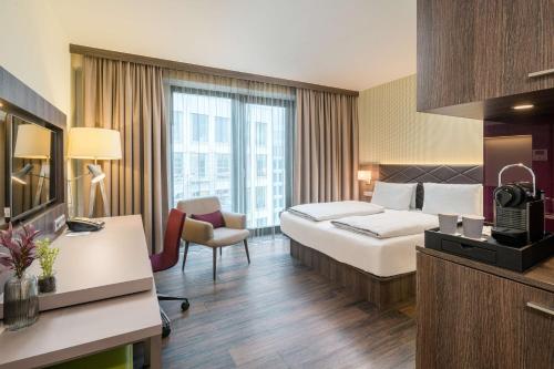 フランクフルト・アム・マインにあるBest Western Hotel Airport Frankfurtのベッドとデスクが備わるホテルルームです。