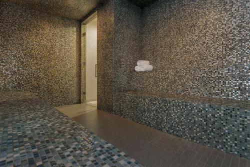 a bathroom with a tub and a tiled wall at Bristol Panama, a Registry Collection Hotel in Panama City