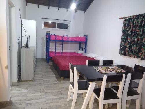 a room with a bed and a table and chairs at Lázaro & Diana in San Clemente del Tuyú