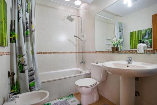 Un baño con lavabo, inodoro y bañera. en Villa Dayely, en Corralejo