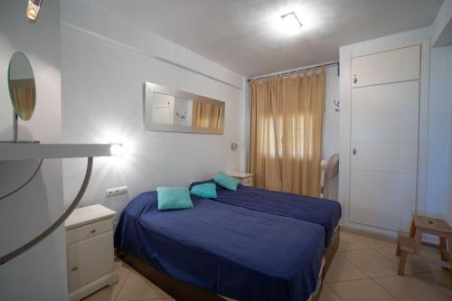 ein Schlafzimmer mit einem blauen Bett mit blauen Kissen in der Unterkunft VERDEMAR 9 MENYBER in Nerja
