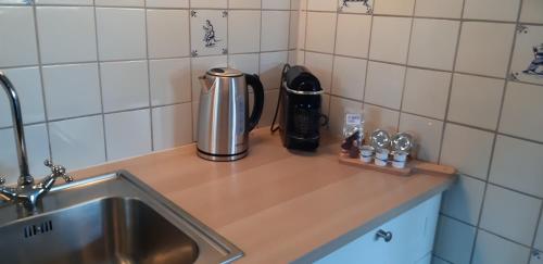 een aanrecht met een wastafel en een koffiepot bij Bij De Vuurtoren in Hollum