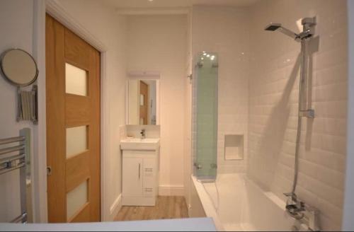 ein Badezimmer mit einer Dusche, einer Badewanne und einem Waschbecken in der Unterkunft Compact, central apartment, dog friendly. in Kingsbridge