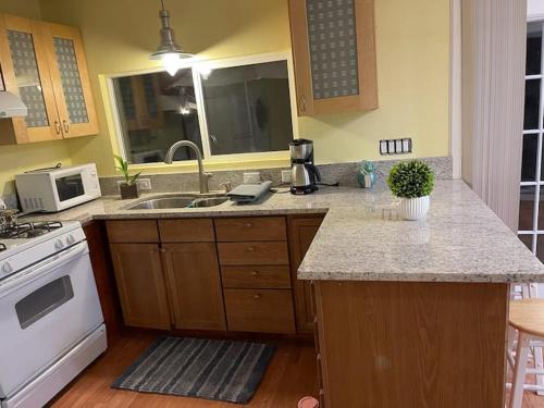 a kitchen with a sink and a stove at Warm and Comfy Antioch Cottage, close to everything in Antioch