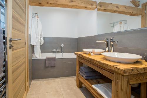 een badkamer met twee wastafels op een houten aanrecht bij Chalet Lumina in Morzine