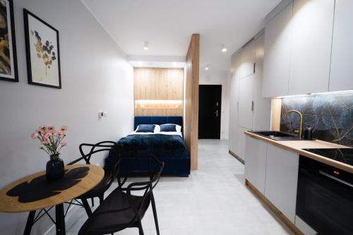 1 dormitorio con 1 cama, mesa y sillas en Apartament pod Szyndzielnią en Bielsko-Biala
