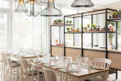 a dining room with a long table and chairs at Best Western Plus Hotel Papenburg in Papenburg