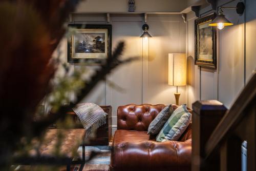 a brown leather couch in a living room with a lamp at Sorley Boys Snug in Derry Londonderry