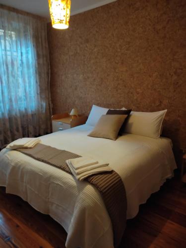 a bed with white sheets and pillows in a bedroom at Appartamento in centro Tollegno in Tollegno