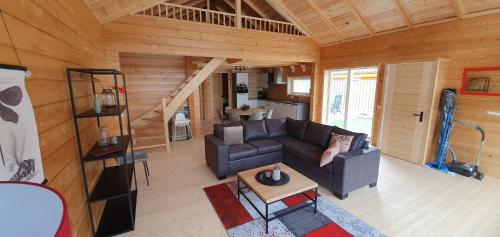 a living room with a couch and a table at Luxe Chalets in Zeeland aan de kust in Sint Annaland