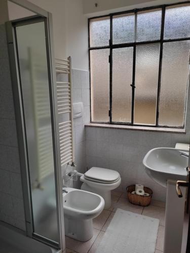 a bathroom with a toilet and a sink and a shower at Appartamento in centro Tollegno in Tollegno