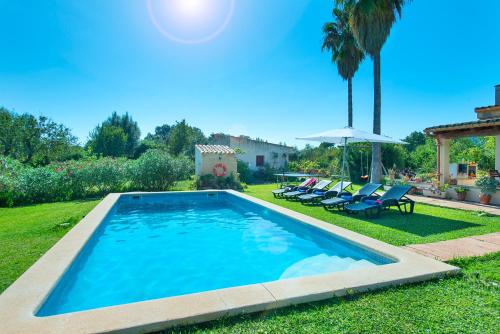 una piscina en un patio con sillas y sombrilla en Owl Booking Villa Punta Magdalena - Family Holidays, en Pollensa