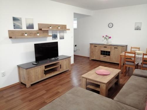 a living room with a television and a table at Apartmány U Stříbrných in Hradec Králové