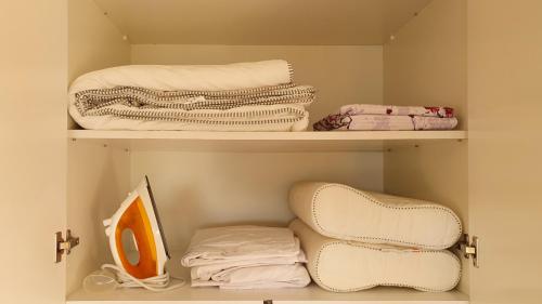 um armário com prateleiras brancas e toalhas dobráveis em Petras Cozy Nest, 1-bedroom apt., Paphos-Universal em Paphos