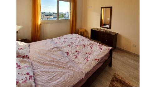 1 dormitorio con 1 cama con tocador y ventana en Petras Cozy Nest, 1-bedroom apt., Paphos-Universal en Paphos