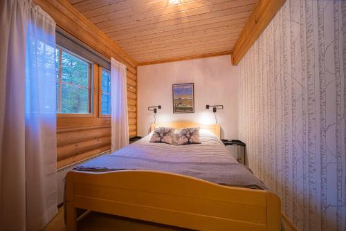 una camera con un letto in una stanza con una finestra di Levillas Kätkänkuja 2A a Levi
