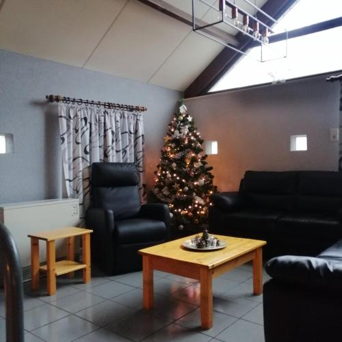 a living room with a christmas tree in the corner at Maison Bonne Humeur Achouffe in Houffalize