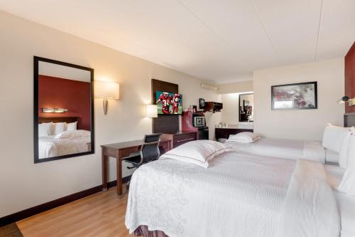 a hotel room with two beds and a desk at Super 8 by Wyndham Deerfield - Northbrook in Deerfield