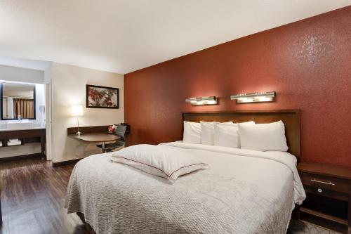 a hotel room with a large bed and a desk at Super 8 by Wyndham Deerfield - Northbrook in Deerfield