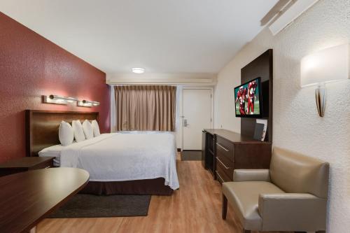a hotel room with a large bed and a desk at Super 8 by Wyndham Deerfield - Northbrook in Deerfield