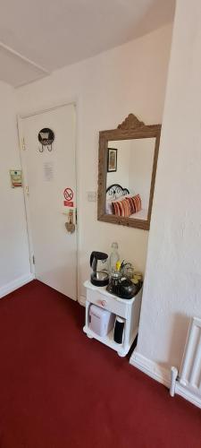 a room with a sink and a mirror on the wall at Holly Cottages in Bowness-on-Windermere
